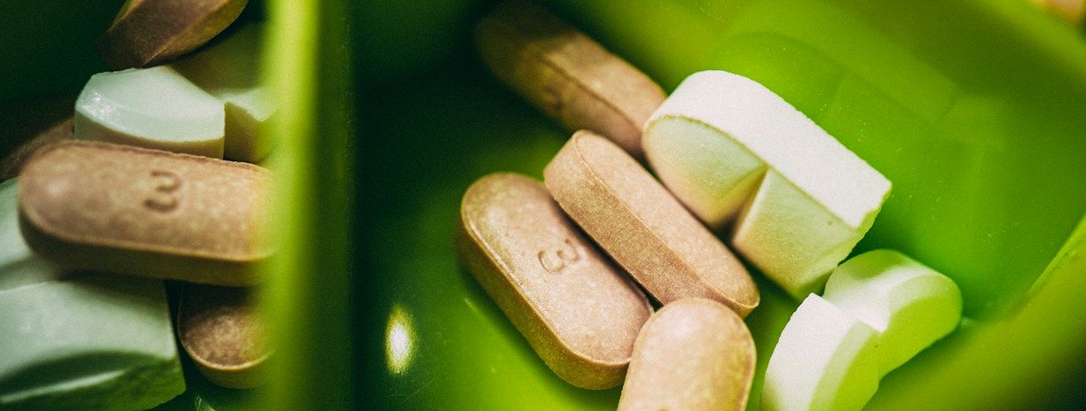 Gélules blanches dans un pilulier vert