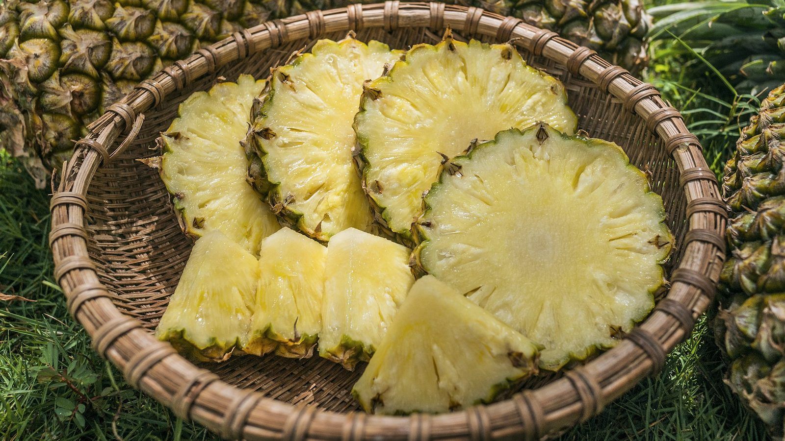 Ananas frais coupé en deux et tronçons de tige à côté de gélules végétales sur une planche en bois