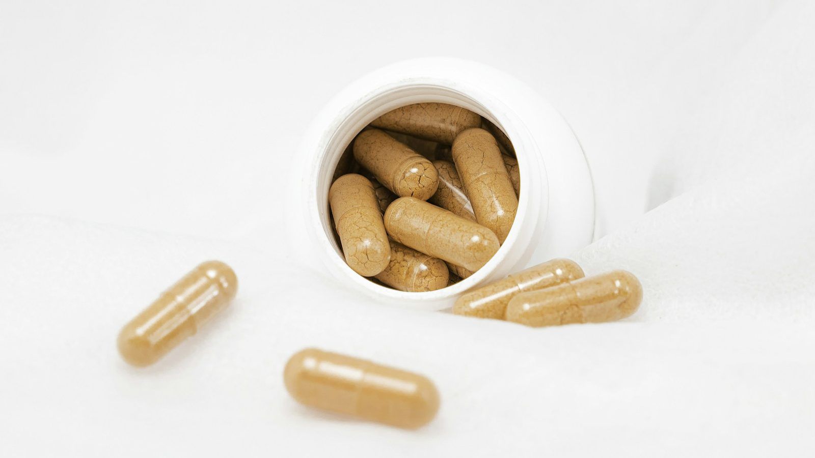 Graines de mucuna pruriens tachetées et gousses velues posées sur une table en bois