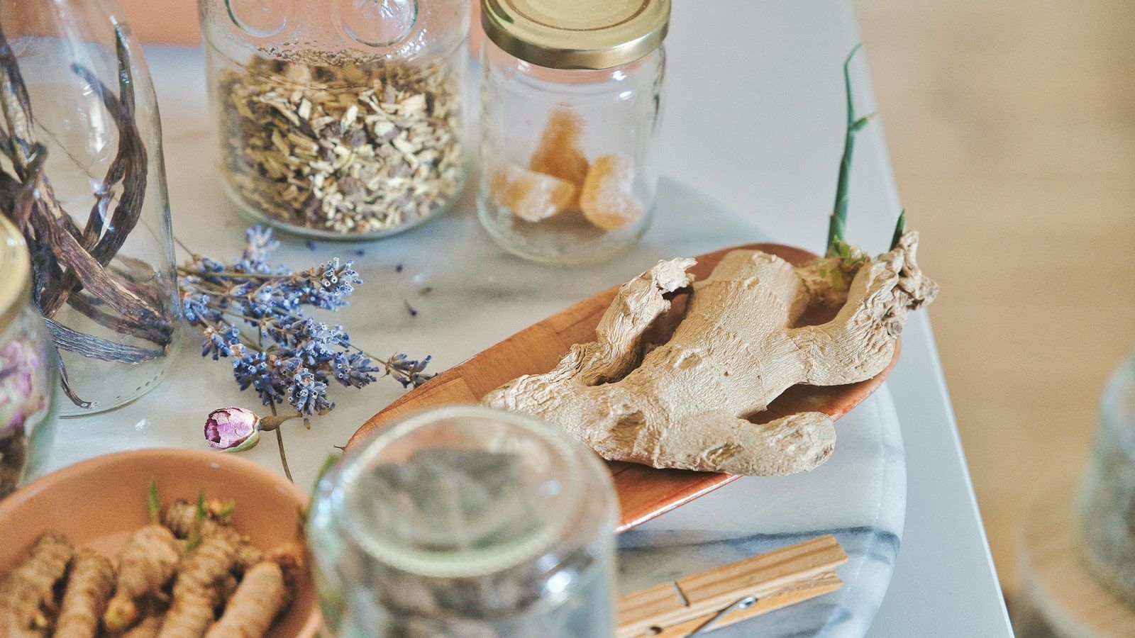 Racines séchées d'ashwagandha, de ginseng et de rhodiola et feuilles de basilic sacré disposées dans des coupelles en bois