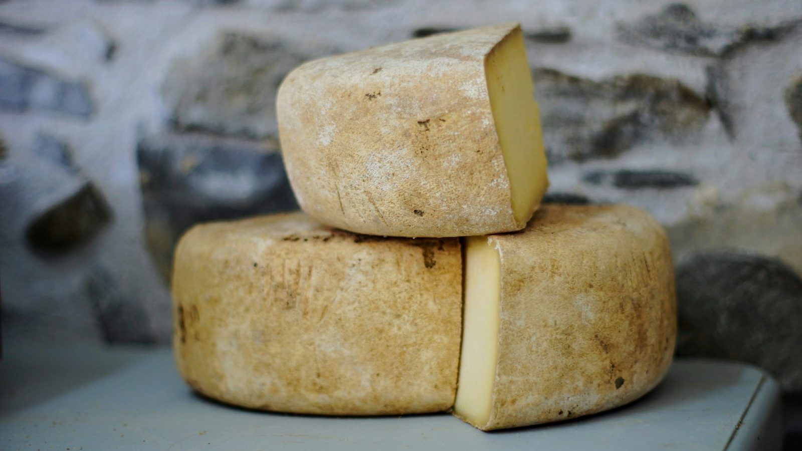 Germe de blé dans une coupelle en céramique à côté de gélules végétales, sur une table en bois clair